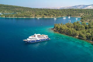 ntrepid cruise ship sailing through blue waters on a sunny day along the Dalmatian coast, Croatia