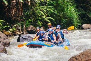 WT Finance Institute travellers whitewater rafting through rapids in the rainforest outside of Ubud, Bali